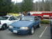 1987 Ford Crown Victoria LTD - A blue 1987 Ford Mustang is parked in a lot with a police car and a fire truck.