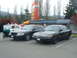 1987 Ford Crown Victoria LTD - Two black police sedans are parked in a lot, with a portion of a two-tone police car visible on the left.