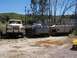 1990 Ford Bronco - Outdoor scene with a tan truck and two grey tracked military vehicles.