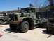 1990 Ford Bronco - A military truck with a camouflage paint scheme is parked next to another military vehicle.