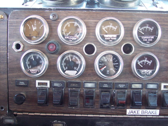 Truck dashboard with fuel, application, temperature, and air pressure gauges. Also has panel lights, fog light, mirror heat, and Jake Brake switches