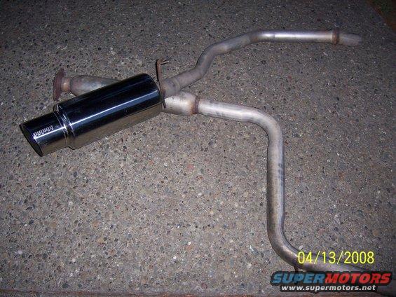 Aftermarket exhaust muffler and pipe assembly on concrete