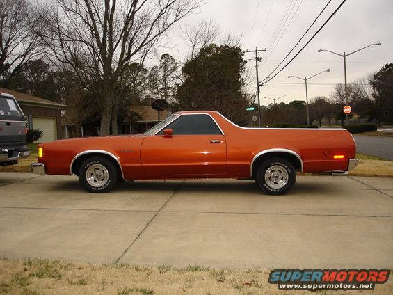 Orange 1979 Ford Ranchero coupe utility, side view, chrome trim, aftermarket wheels, parked on driveway