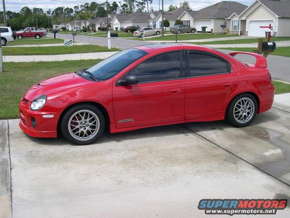 Red Dodge Neon SRT-4 with aftermarket wheels parked on a driveway