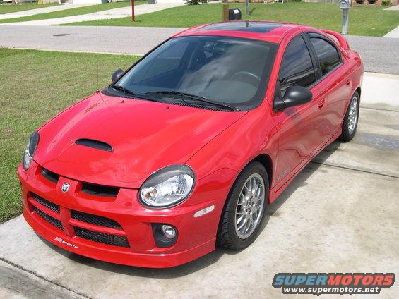 Red Dodge Neon SRT-4 with hood scoop and spoiler parked on a driveway