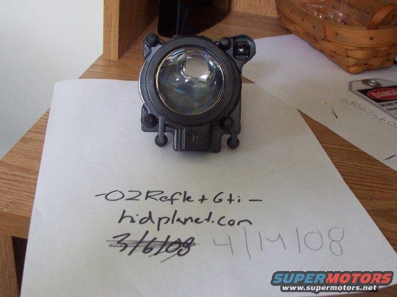 Automotive headlight assembly with handwritten text '-O2Refle+Gti- hidplanet.com 3/6/09 4/14/08' and Supermotors logo