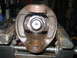 1994 Ford Bronco - Close-up of a damaged drive shaft universal joint, held securely in a vise for repair.