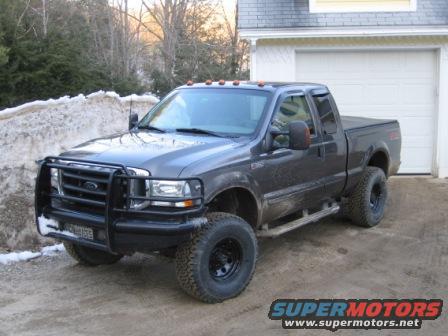 Dark gray pickup truck with brush guard and black wheels, front 3/4 view