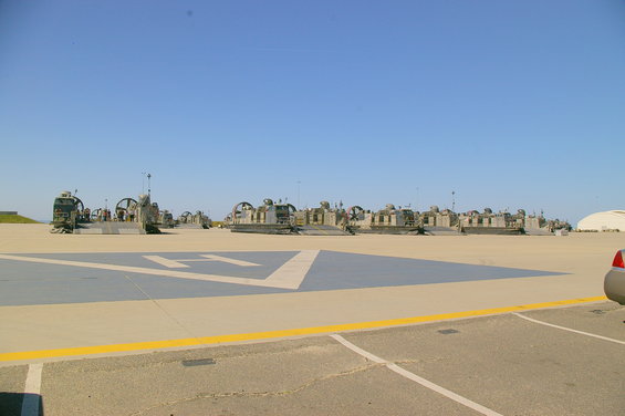 Row of hovercrafts on a paved surface under a clear blue sky