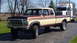 1979 Ford F-350 - This 1979 Ford F-350 SuperCab pickup truck is seen from a 3/4 front angle, with a semi-truck visible in the background.
