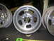 1987 Ford Bronco - Several aluminum alloy wheels are shown, with a tape measure in the foreground.
