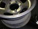 1987 Ford Bronco - A close-up view of a single aluminum wheel, showing the lug nut holes and the rim's edge.