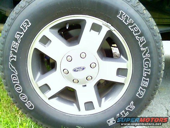 Goodyear Wrangler AT/S tire on a silver 5-spoke wheel with a Ford logo center cap