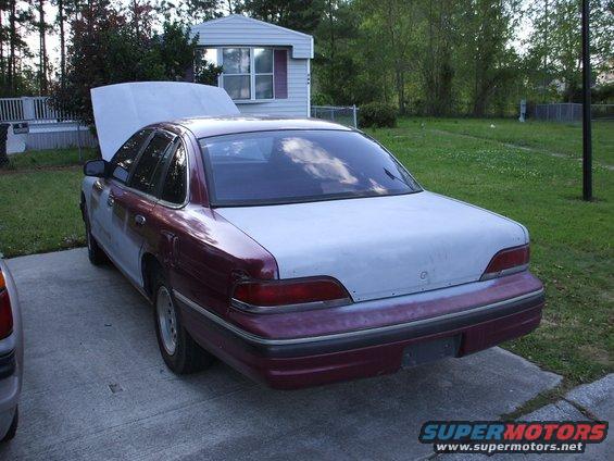 Maroon and grey sedan with hood open, parked on concrete driveway
