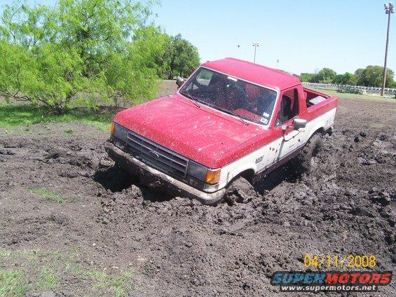 1988 Ford Bronco stuck in mud, 3q-front view, red and white