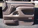 1996 Ford Bronco - Tan interior door panel from a 1996 Ford Bronco, showing storage compartments and a vent.