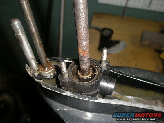 Boat motor lower unit with rusty metal rods and bolts, close-up view