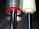 1996 Ford Bronco - Comparison of two different shock absorbers, highlighting their construction and mounting points.