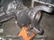 1979 Ford Bronco - Close-up of a vehicle's differential housing and a suspension component, supported by an orange jack stand.