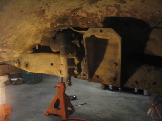 Close-up of rusty vehicle frame and suspension on jack stands