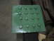1979 Ford Bronco - A green metal plate with a grid of 16 bolts is shown, likely a component for a vehicle.