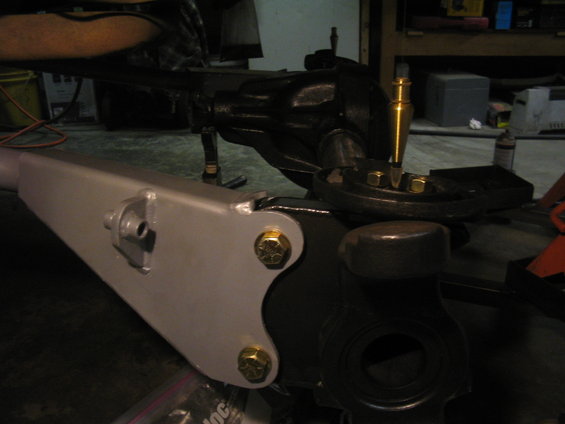 Gray metal bracket bolted to black differential housing with gold bolts