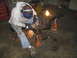 1979 Ford Bronco - A person grinds an axle assembly supported by jack stands in a garage.