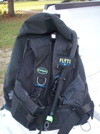 Black scuba BCD with Dacor and Flytpak logos, and a corrugated hose