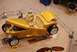 1996 Ford Bronco - A gold custom hot rod roadster is displayed with its hood and doors open, revealing its tan interior and chrome accents.