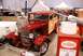 1996 Ford Bronco - A custom red and wood-paneled hot rod is displayed indoors, with a large can of red paint in the foreground.