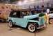 1996 Ford Bronco - A vintage Jeep Willys CJ-3A is displayed indoors with its hood up, next to other vehicles and a trailer.