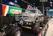 1996 Ford Bronco - A heavily modified pickup truck with oversized tires and a drag racing chassis is displayed next to a Castrol banner.