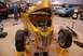 1996 Ford Bronco - A custom gold hot rod is displayed with its hood open, revealing the engine, at an indoor car show.