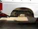 1996 Ford Bronco - The rear suspension and frame of a white vehicle are visible, with a red toolbox in the background.
