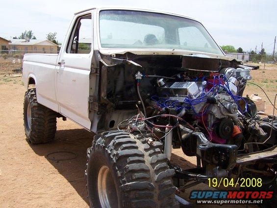 White Ford pickup truck, front end disassembled, showing engine and large off-road tires. Date stamp reads 19/04/2008
