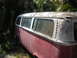 1971 Volkswagen Vanagon - A weathered red and white Volkswagen Type 2 van sits abandoned amongst overgrown vegetation.