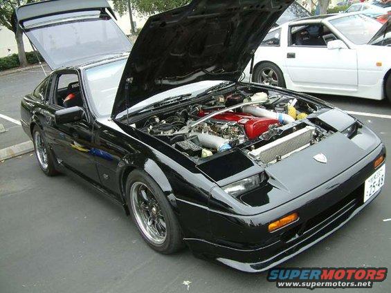 Black 1988 Nissan 300ZX with engine exposed, parked next to a white car