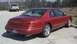 1996 Lincoln Mark VIII - Rear view of a red 1996 Lincoln Mark VIII parked outdoors, a pickup truck is visible in the background.