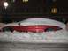 1996 Lincoln Mark VIII - A red car is almost completely covered by snow, with only a portion of its side visible.