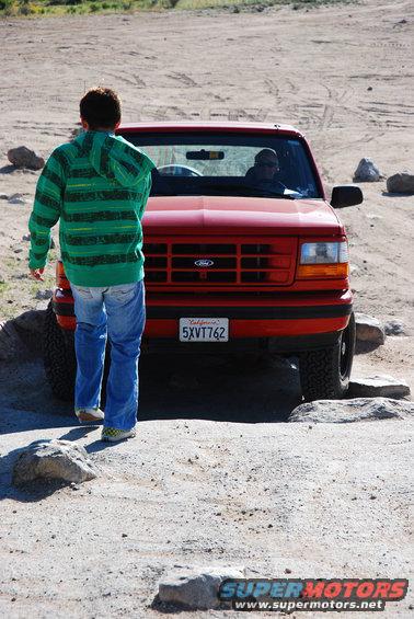 1995 Ford Bronco front view with person walking towards it on dirt road