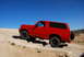 1995 Ford Bronco - Red 1995 Ford Bronco navigating rocky terrain off-road.