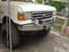 1989 Ford Bronco - Front view of a white 1989 Ford Bronco, modified with a winch mount bumper and off-road tires.