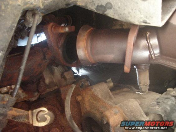 close-up of rusty exhaust pipe and catalytic converter connection