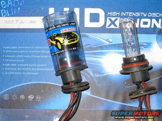 Two HID Xenon headlamp bulbs with blue and yellow packaging showing a car graphic