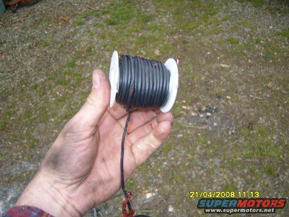 Spool of black wire held in a hand