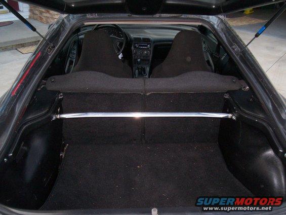 View of car's interior and open trunk with a strut bar
