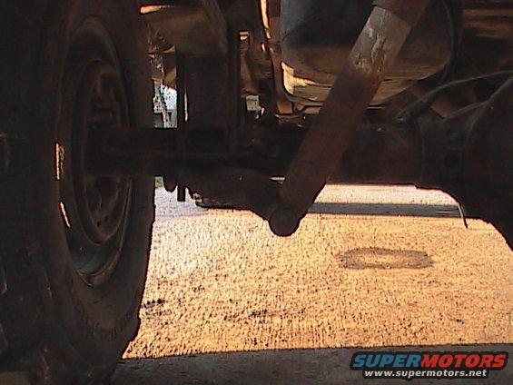 Close-up of rear axle, shock absorber, and tire of a vehicle