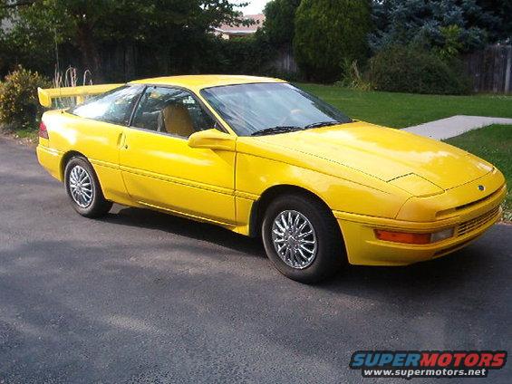Yellow 1992 Ford Probe coupe with a rear spoiler, seen from the front-right