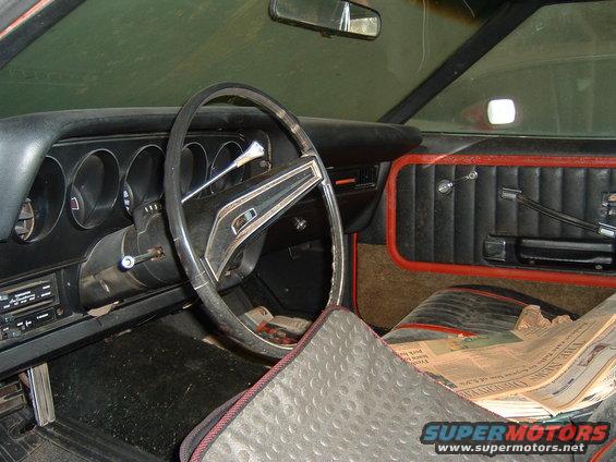 1979 Ford Ranchero interior showing dashboard, steering wheel, door panel, and newspaper on seat