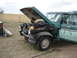 1979 Ford F-150 - A green 1979 Ford F-150 pickup truck sits outdoors with its hood open, revealing the engine compartment and some front-end damage.